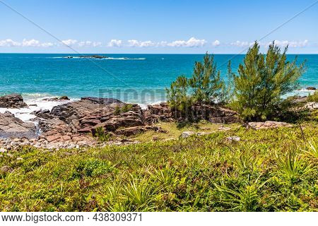 Beach View With Waves, Rocks And Vegetation