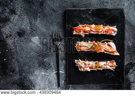 Crab Leg Meat In A Sheel With Herbs. Black Background. Top View. Copy Space