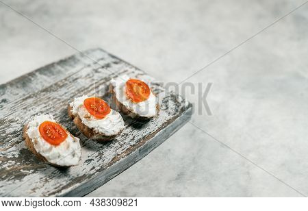 Three Cream Cheese Sandwiches With Tomatoes On The Wooden Board On Grey Background, Free Space For T