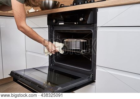 Woman Open Electric Oven Door To Chek In Baking Cake. Homemade Cooking. Kitchen Appliance