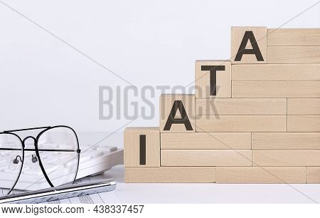 Wooden Cubes With Letters Iata On White Table With Keyboard And Glasses