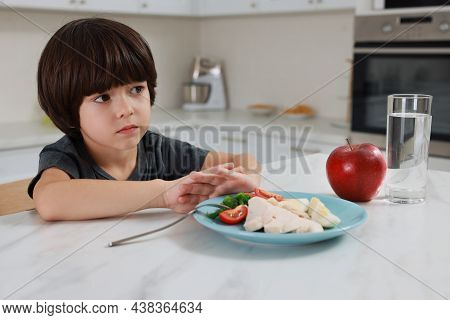Cute Little Boy Refusing To Eat Dinner In Kitchen