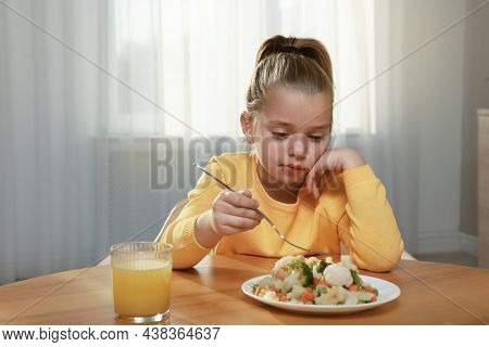 Cute Little Girl Refusing To Eat Vegetable Salad At Home