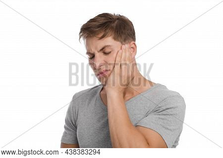 Unhappy Sad Millennial Caucasian Man Presses Hand To Cheek And Suffers From Toothache