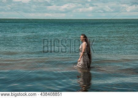 Girl With Long Hair Posing In Water. Treavel By The Sea