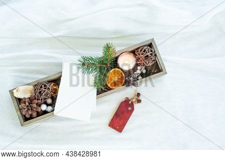 Christmas Decorations In Small Wooden Box. Blank Greeting Card Mockup Among Fir Twig, Candle, Dried 
