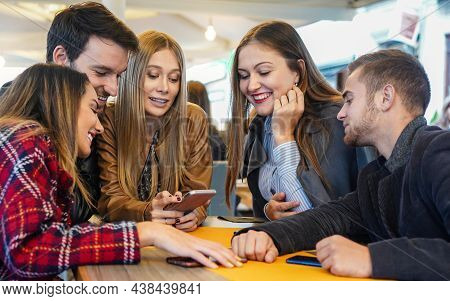 Group Of Friends Hanging Out With Each Other Sitting In A Bar Using Their Mobile Phones - Young Peop