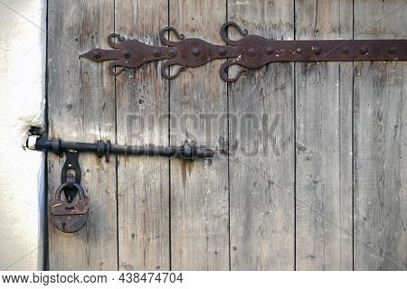 The Wooden Door Made Of Planks Is Decorated With A Decorative Element Of Wrought Iron In The Russian