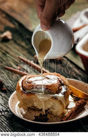 Cinnamon Rolls Or Cinnabon On A Plate On A Wooden Table. Food Recipe Background. Close Up.