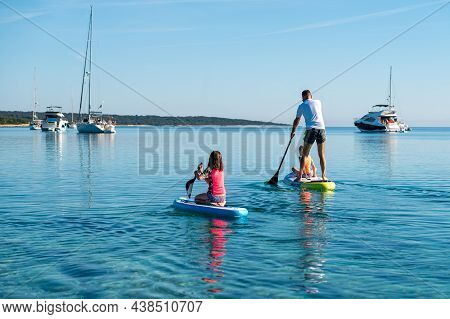 Happy Family On Sup Stand Up Paddle On Vacation.