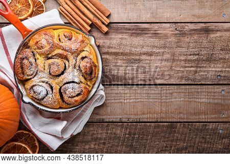 Cinnabon Cinnamon Rolls Buns With Pumpkin, Nut, Caramel And Sugar Cream Iced On Rustic Wooden Backgr