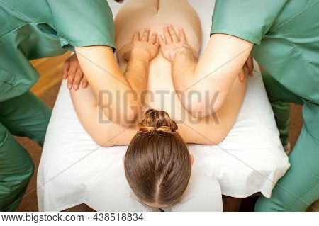 Back And Hands Double Massage With Four Hands Of Two Professional Massagers For A Young Caucasian Wo