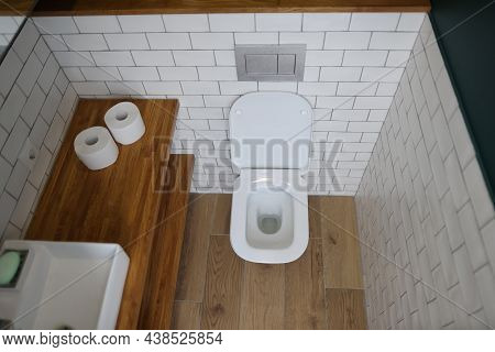 Top View Of Modern Bathroom Interior With Wooden Shelves, White Sink And Toilet. Fresh Interior In D
