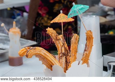 Homemade Crunchy Churros In Paper Box At Summer Outdoor Food Market - Close Up View. Traditional Spa