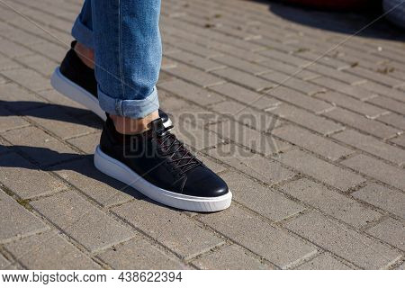 Men's Sneakers Or Shoes Made Of Genuine Leather On Men's Legs Close-up.