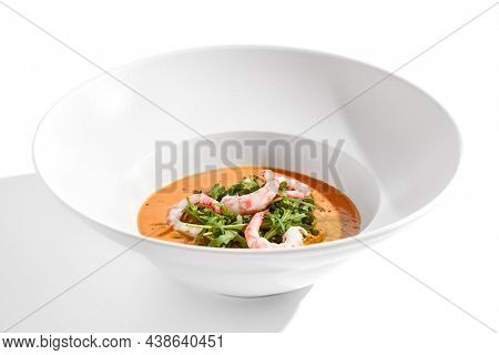 Summer Spanish soup gazpacho with shrimp and rocket salad isolated on white background. Healthy cold tomato soup with prawns. Clean eating for diet.Healthy food in restaurant menu. Seafood gazpacho