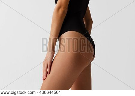 Back View Of Sportive Body, Bottocks Of Young Woman Isolated On Gray Studio Background. Natural Beau