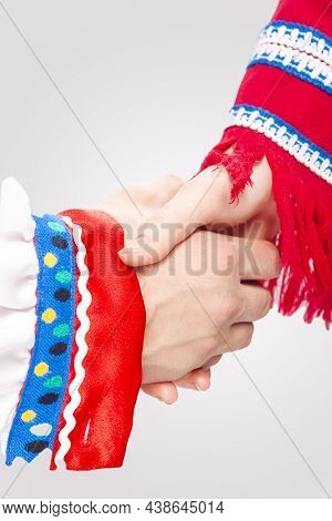 Two Hands Of Caucasian Couple Connected Together In National Costumes Demonstrating Support And Encu