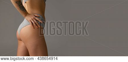 Side View Of Sportive Body, Bottocks Of Young Woman In Grey Bottocks Isolated On Gray Studio Backgro