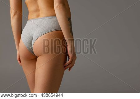 Back View Of Sportive Body, Bottocks Of Young Woman In Grey Bottocks Isolated On Gray Studio Backgro
