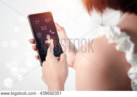 A Young Asian Woman Uses Her Right Hand To Hold A Mobile Phone With A Black Screen (focus) And Her L