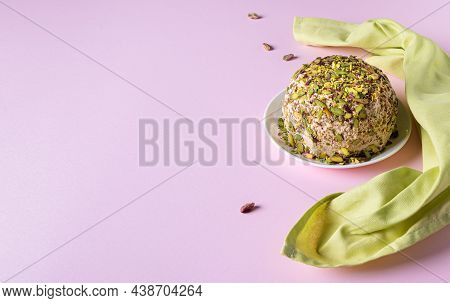 Halva With Pistachios, Scatterred Nuts And Green Linen Napkin On Pink Paper. Horizontal Orientation.