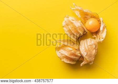 Physalis peruviana. Cape Gooseberry or ground cherries fruit on yellow background. Top view.