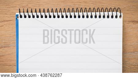Top Of Spiral Bound Notebook Open On A Wooden Desk, Flat Lay Ideal For Background Or Template