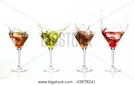 Disposizione seriale dei liquidi colorati schizzi nel bicchiere da cocktail su sfondo bianco