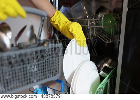 Close-up Of Woman Loading Dishwasher, Open Dishwasher With Clean Plates After Washing. Modern Kitche