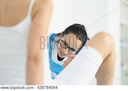 Portrait Of Patient Lay With Legs Spread Apart, Examination By Female Gynecologist. Gynecology Consu