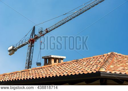 Construction Site With Tower Crane And A Closeup Of A Roof With Terracotta Tiles (coppo In Italian L