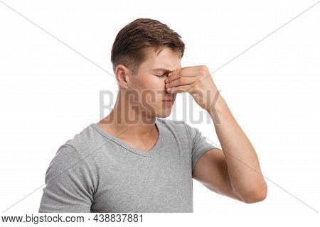 Despaired Sad Millennial European Male Presses Hand To Nose, Suffers From Migraine Or Runny Nose