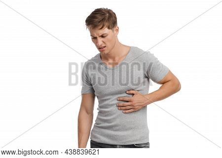 Unhappy Sad Millennial European Attractive Man Presses His Hand To Sore Spot And Suffers From Stomac