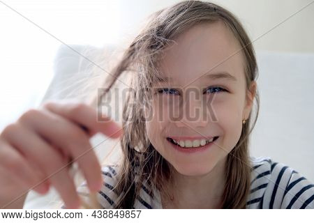Smiling Girl Holding Tangled Hair In Her Hand
