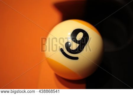 Pool Ball Number 9 Close-up On Billiard Board On Blurred Background