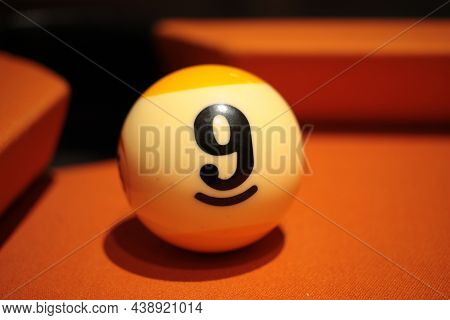 Pool Ball Number 9 Extreme Close-up On Blurred Background Of American Billiards Playing Surface