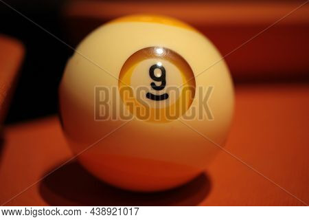 Pool Ball Number 9 Extreme Close-up On Blurred Background Of American Billiards Playing Surface
