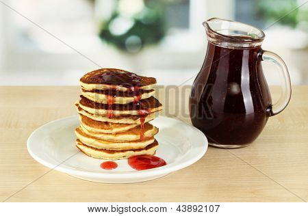 หวาน pancakes บนแผ่นกับแยมบนโต๊ะในห้องครัว