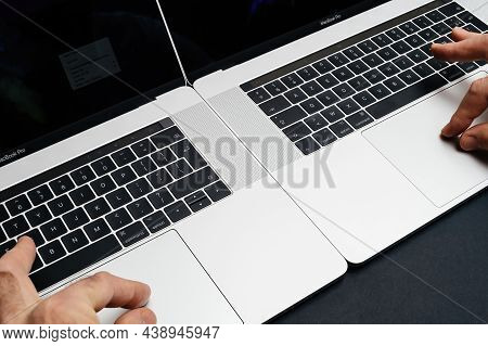 London, United Kingdom - Jan 9, 2018: Male Hand Operating Two Laptop Simultaneously Professional App