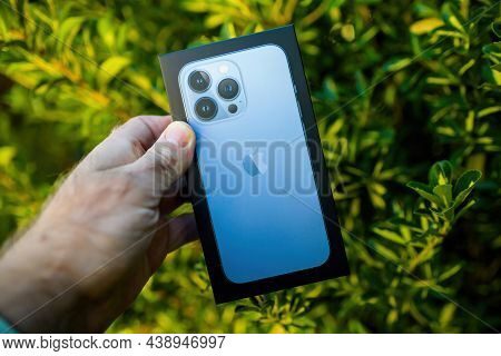 Paris, France - Oct 21, 2021: Pov Male Hand Holding Near Eleagnus Japonicus Branch New Cardboard Pac