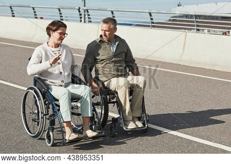 Full Length Portrait Of Mature Couple In Wheelchairs Chatting Outdoors And Enjoying City Life, Copy 