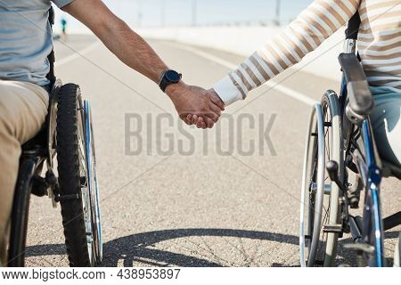 Close Up Of Couple In Wheelchairs Holding Hands Outdoors, Love And Support Concept, Copy Space