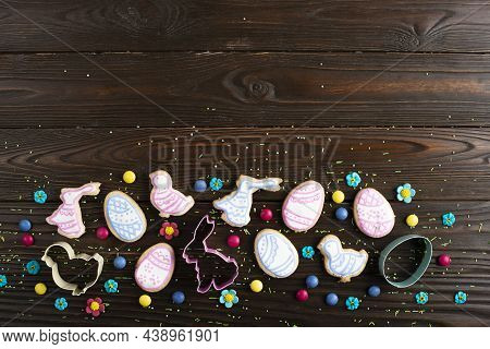 Cookie Cutters And Easter Frosted Cookies In Shape Of Egg, Chicken And Rabbit On Dark Wooden Backgro
