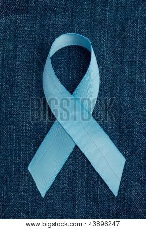 Nastro azzurro per la consapevolezza del cancro della prostata sdraiato sul blu demin