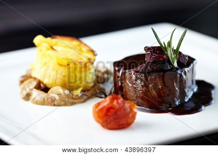 Filetto di manzo arrosto con muffin alle erbe-patate, ragù di funghi, pomodori al forno e rosmarino-curran