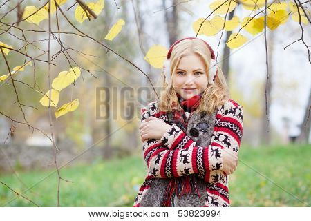 girl in fur headphones in the autumn park