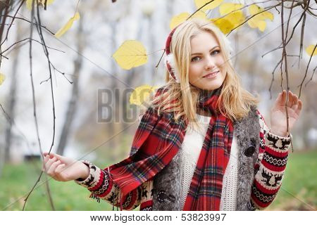 girl in fur headphones in the autumn park