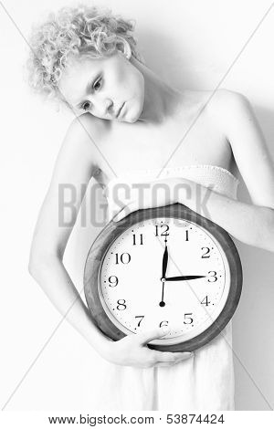 Scrawny girl with big clock in hands, black and white photo.