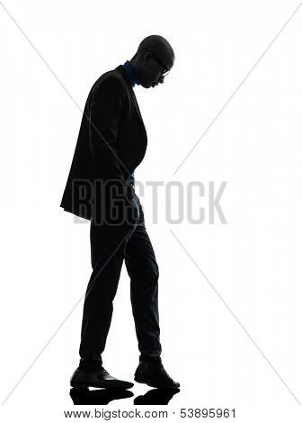 one african  black man standing looking down  in silhouette studio on white background